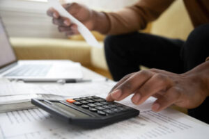 start business with little. Close up of a man with calculator checking bills at home. Savings, finances, economy concept. small business owner calculating income and planning budget 